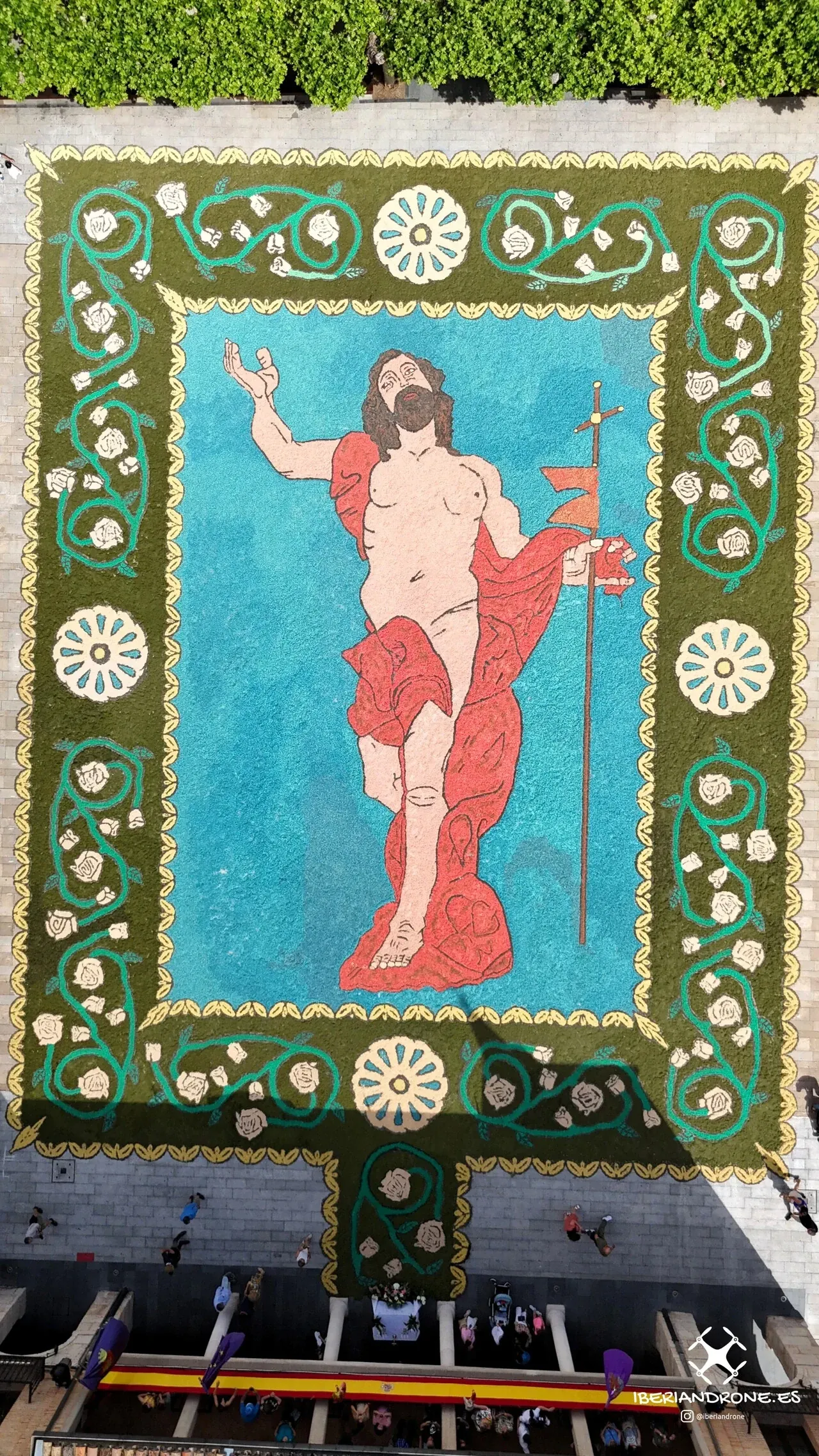 Alfombra de serrín tintado con una figura de Cristo, vista en cenital con dron en el Corpus Christi 2025 de El Burgo de Osma
