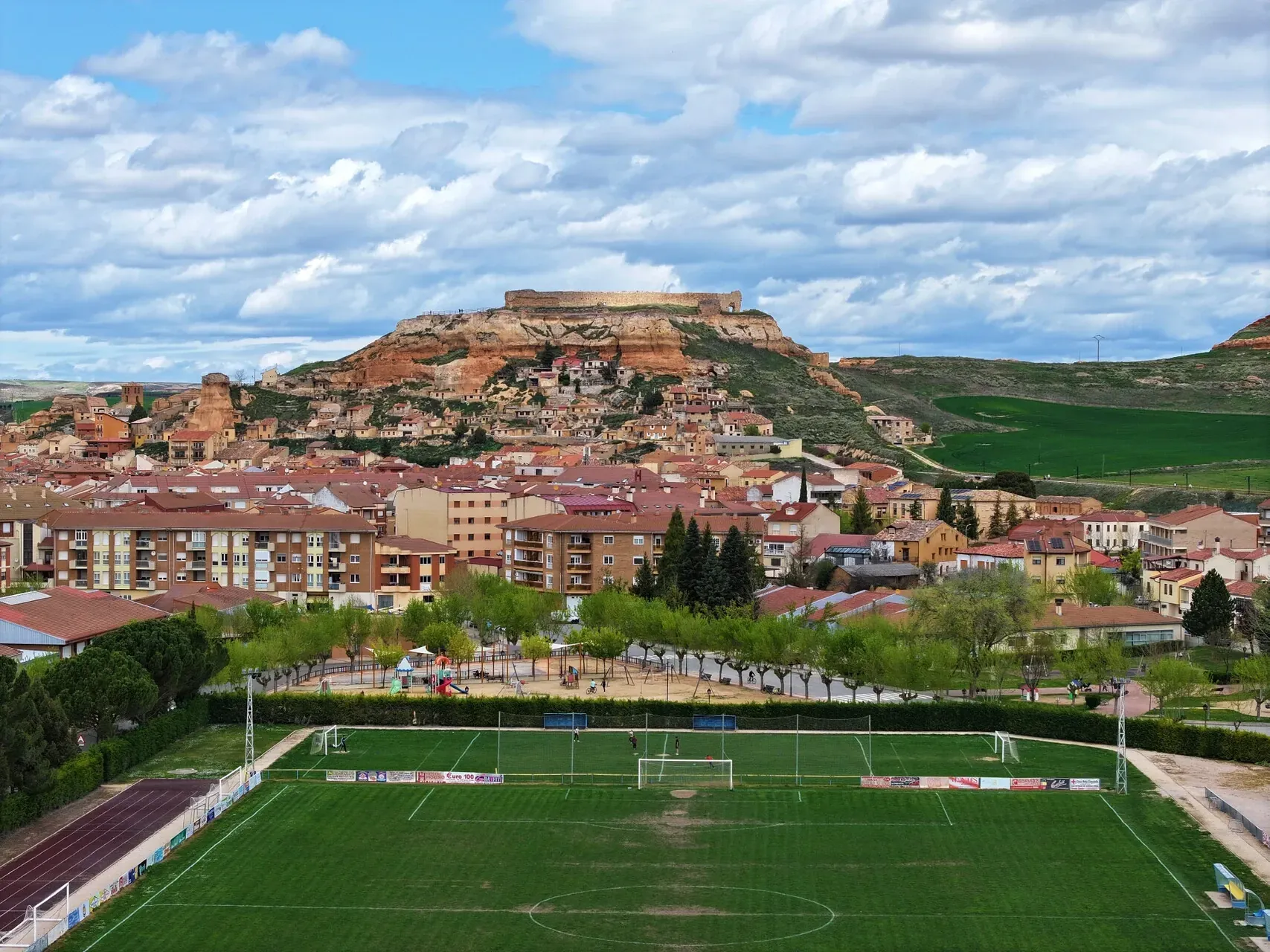 El campo de fútbol de San Esteban de Gormaz visto con dron, con el pueblo y el cerro del castillo al fondo