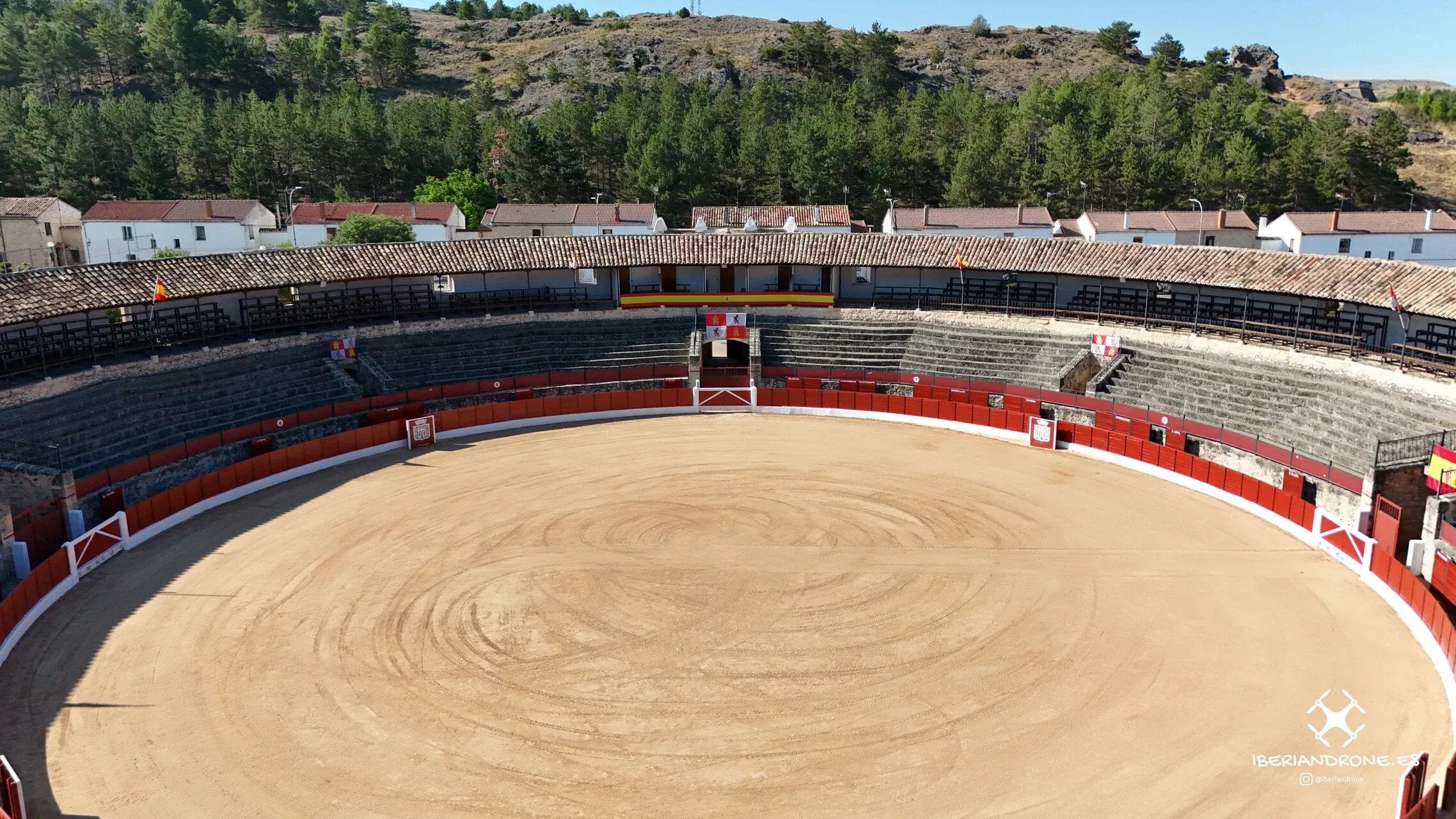 El ruedo y los tendidos desde el aire, con los pinares al fondo.